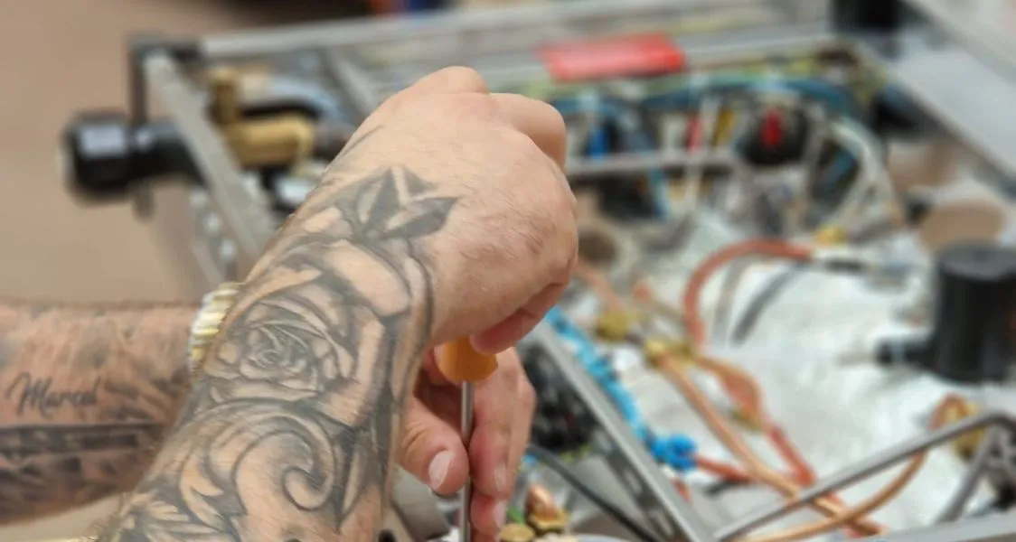 Technicien réparant le circuit électrique d'une machine à café professionnelle
